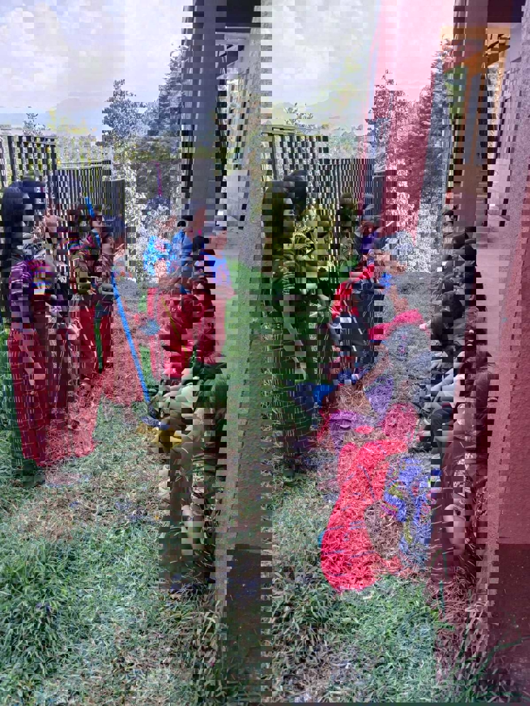 en gruppe barn som sitter på bakken utenfor en bygning