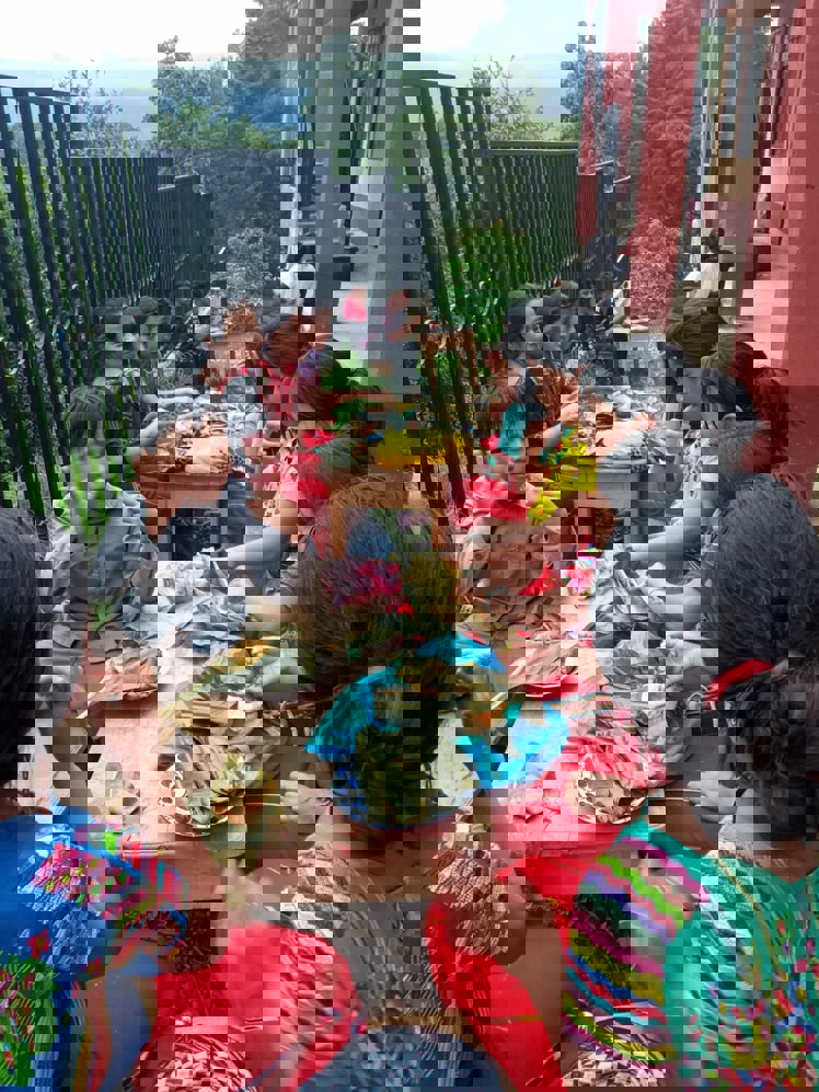 en gruppe mennesker som sitter rundt et bord og spiser mat